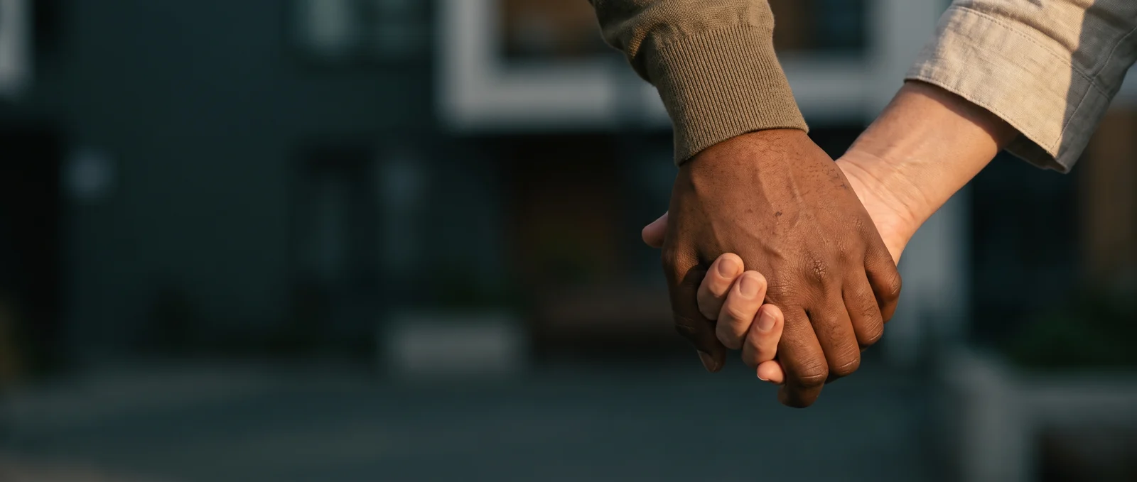 Two adults sharing a supportive hand clasp